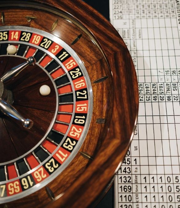 roulette wheel beside a sports betting board with odds and numbers.